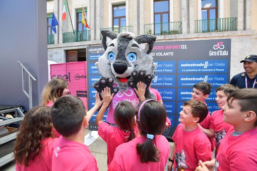 La mascotte del Giro "Wolfie" insieme ai bambini del progetto BiciScuola al Giro d'Italia 2018 La mascotte del Giro "Wolfie" insieme ai bambini del progetto BiciScuola al Giro d'Italia 2018