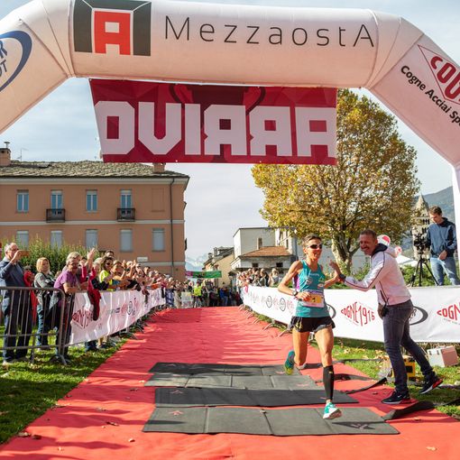 Catherine Bertone all'arrivo della Mezzaosta 2019 applaudita da Jean Dondeynaz presidente Fidal VdA