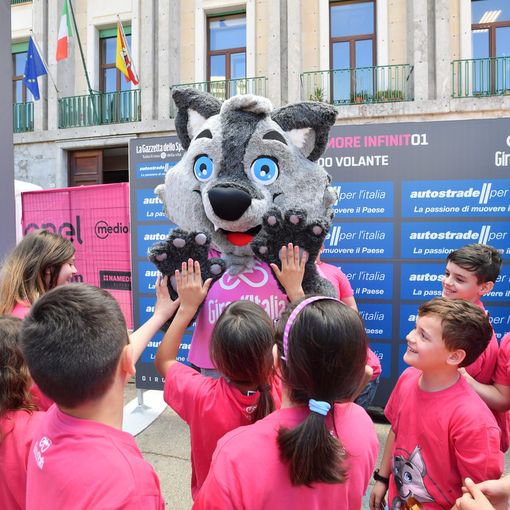La mascotte del Giro &quot;Wolfie&quot; insieme ai bambini del progetto BiciScuola al Giro d'Italia 2018