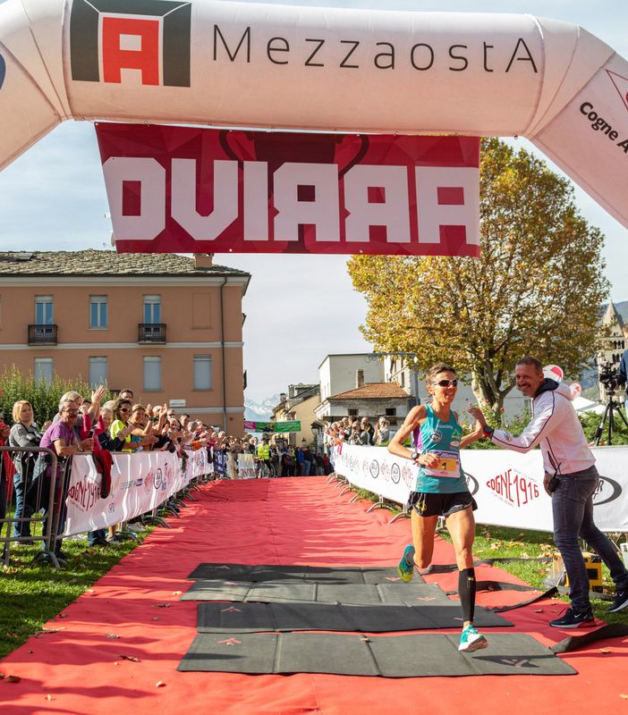 Catherine Bertone all'arrivo della Mezzaosta 2019 applaudita da Jean Dondeynaz presidente Fidal VdA